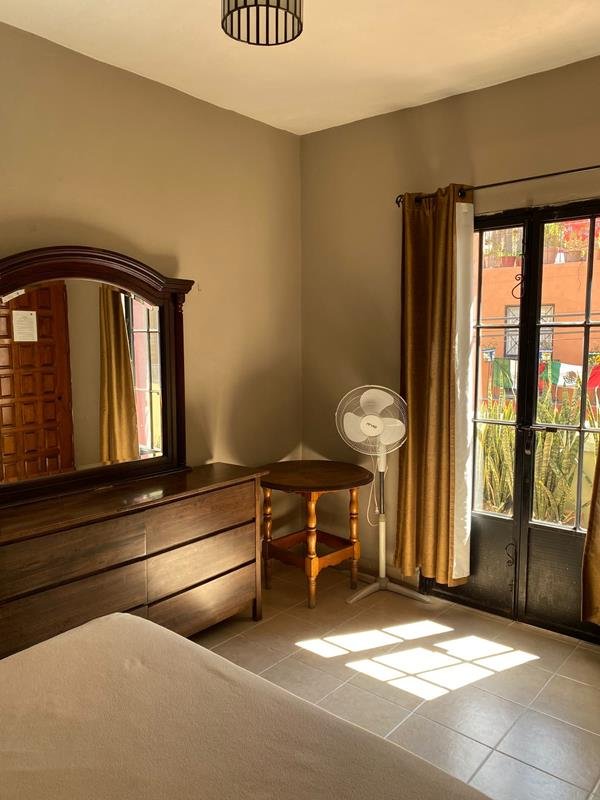 Habitación con cómoda, espejo y balcón