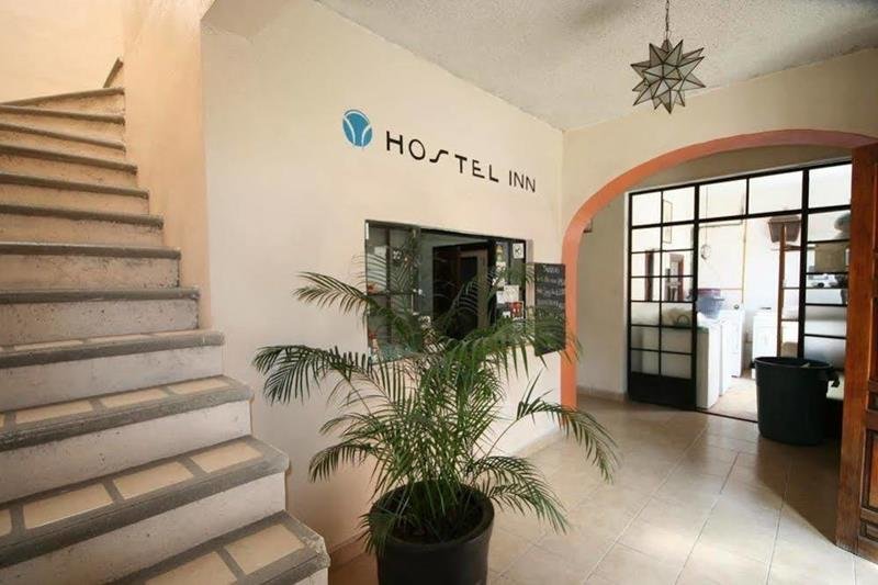 Recepción de Hostel Inn con el logotipo en la pared